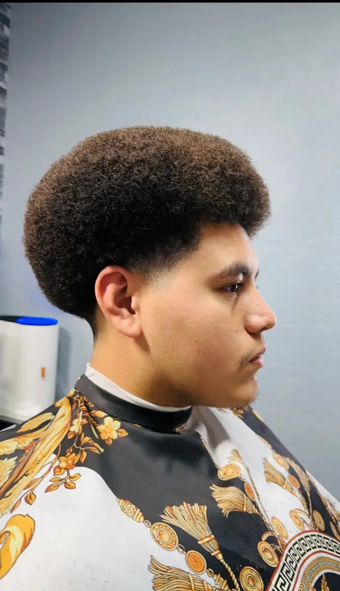 Natural textured hairstyle shaped with a clean taper