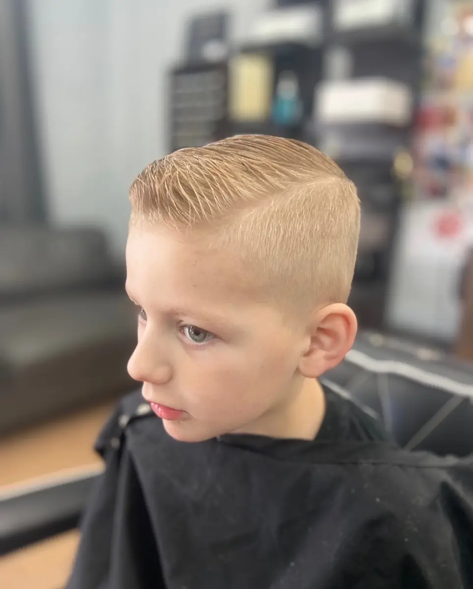 Kids haircut with a defined side part and clean taper